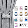 A set of four silver magnetic curtain tiebacks displayed against a gray fabric background.
