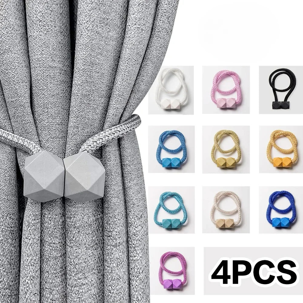 A set of four silver magnetic curtain tiebacks displayed against a gray fabric background.