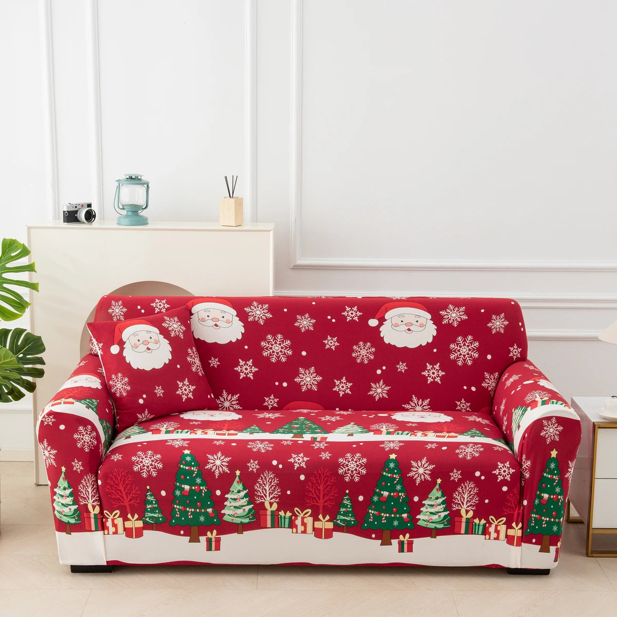 A red festive sofa cover featuring a white Christmas pattern with green trees and gifts.