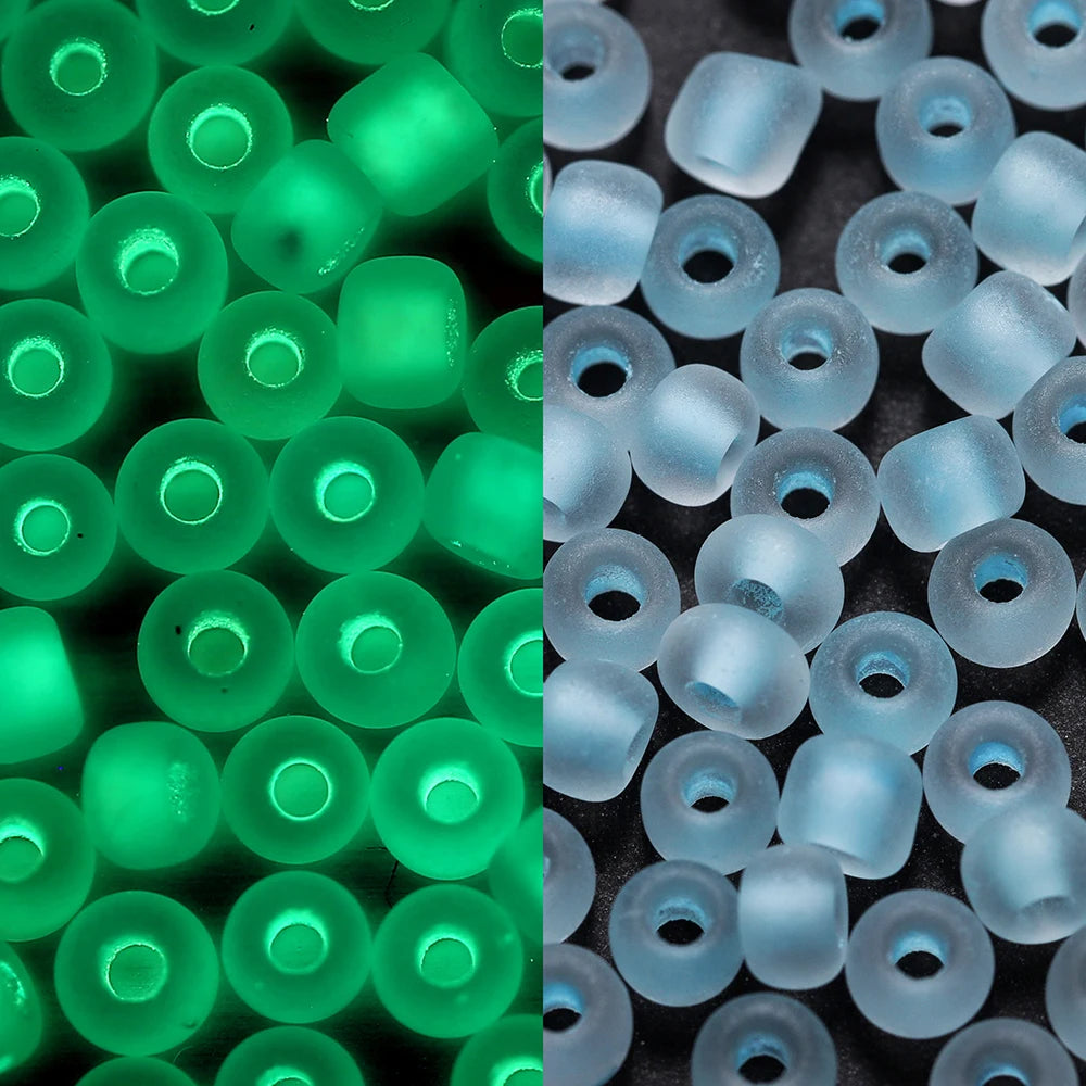 A close-up view of green and blue glow-in-the-dark glass seed beads in various sizes