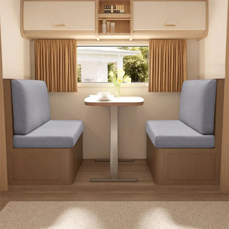 A modern interior featuring two upholstered armchairs with light blue cushions and a small wooden table.