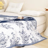 A white duvet cover featuring a detailed black floral pattern on a bed.