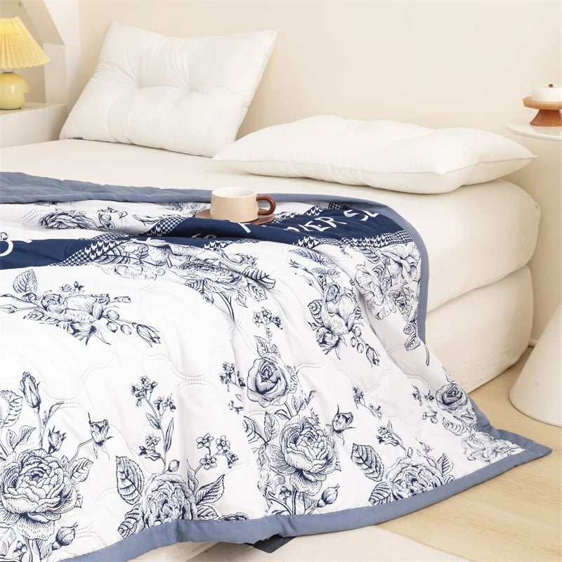 A white duvet cover featuring a detailed black floral pattern on a bed.