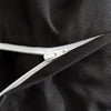 Close-up of a black duvet cover with a silver zipper detail.