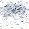 A pile of silver safety bulb pins for knitting and sewing scattered on a white surface.