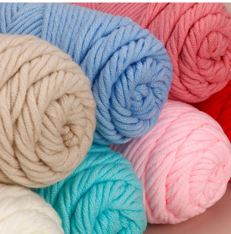A close-up of various skeins of pink, blue, and beige cotton yarn in a ball or skein format.