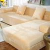 A light beige velvet sofa cover for an L-shaped sectional sofa with throw pillows.
