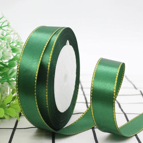 Roll of emerald green satin ribbon with a gold edge for gift wrapping and crafts