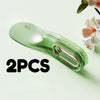 Two green silicone mattress lifters or bed linen organizers are shown on a light green surface.