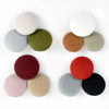 A set of round fabric-covered shank buttons in various shades of beige, green, gray, and terracotta.