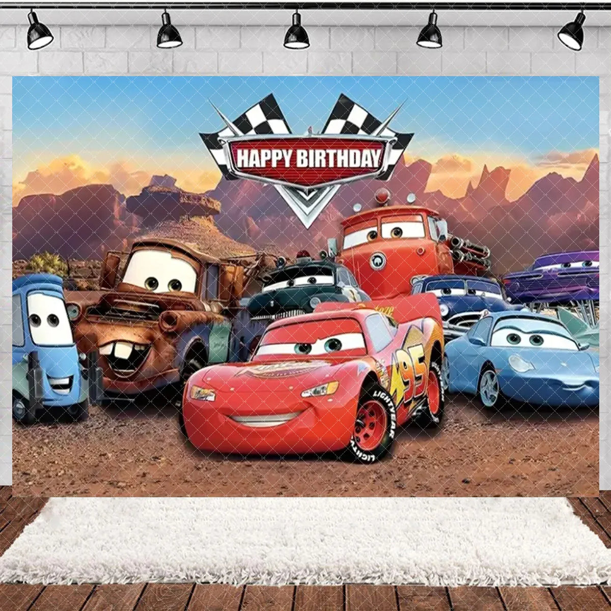 A backdrop featuring various cartoon race cars celebrating a happy birthday with mountains in the background.