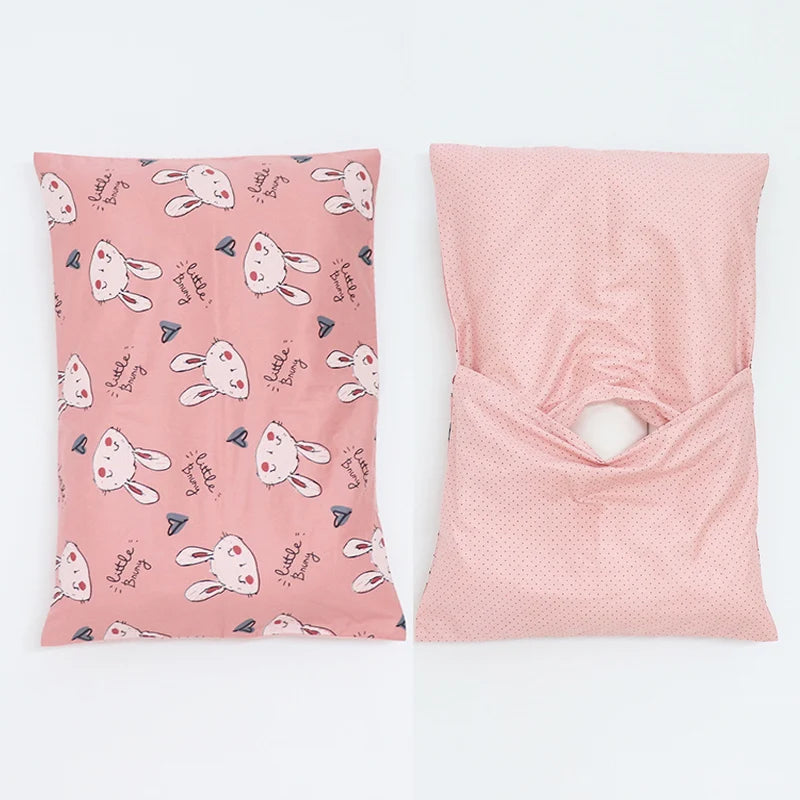 A pink soft cotton baby pillow cover featuring a pattern of little bunny faces.