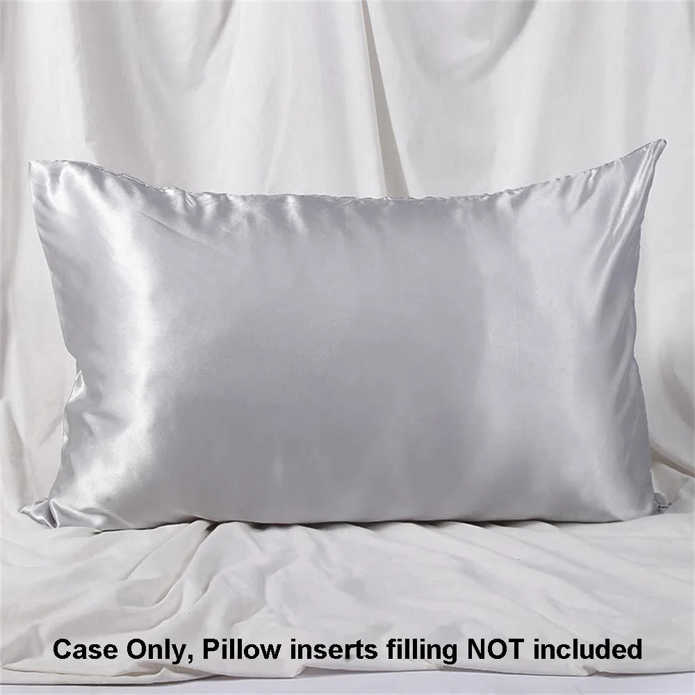 A smooth, silver satin pillowcase is displayed against a white fabric background.