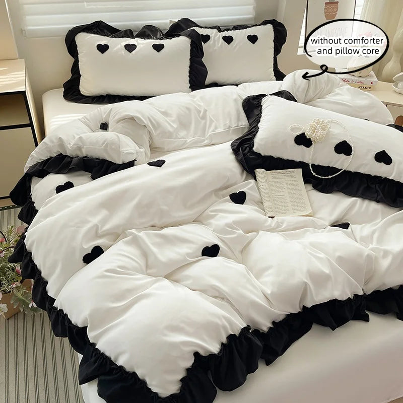 White duvet set with black embroidery featuring heart patterns and pillow covers