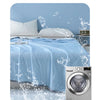 A light blue quilt being washed in a machine with water, demonstrating the fabric's ability to resist fading.