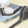 A roll of black and white iron-on hem tape is shown next to a white mannequin head.