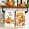 A set of two kitchen towels featuring an orange and white plaid design with pumpkins and foliage.