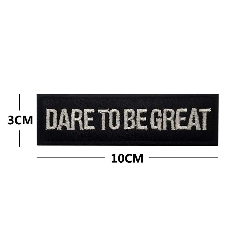 Black embroidered patch with the text DARE TO BE GREAT, measuring 10cm long.
