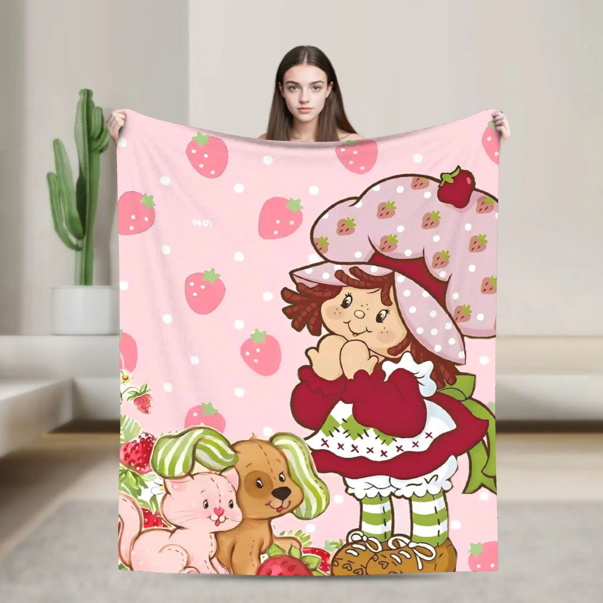 A pink strawberry shortcake plush throw blanket featuring a character and fruit patterns.