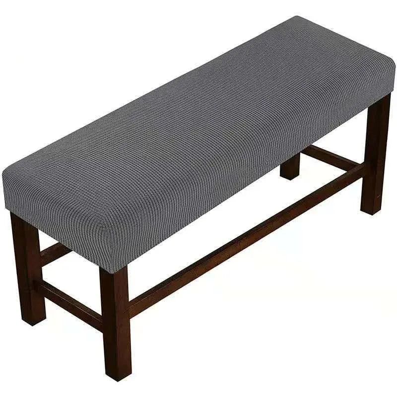 A gray elastic stool cover for living room seating with a wooden frame.