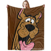 A person holding a Scooby-Doo dog graphic flannel throw blanket.
