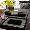 A set of minimalist geometric table runner placemats featuring black and white patterns on a dark table.
