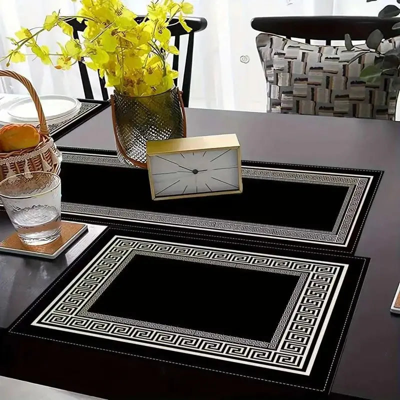 A set of minimalist geometric table runner placemats featuring black and white patterns on a dark table.