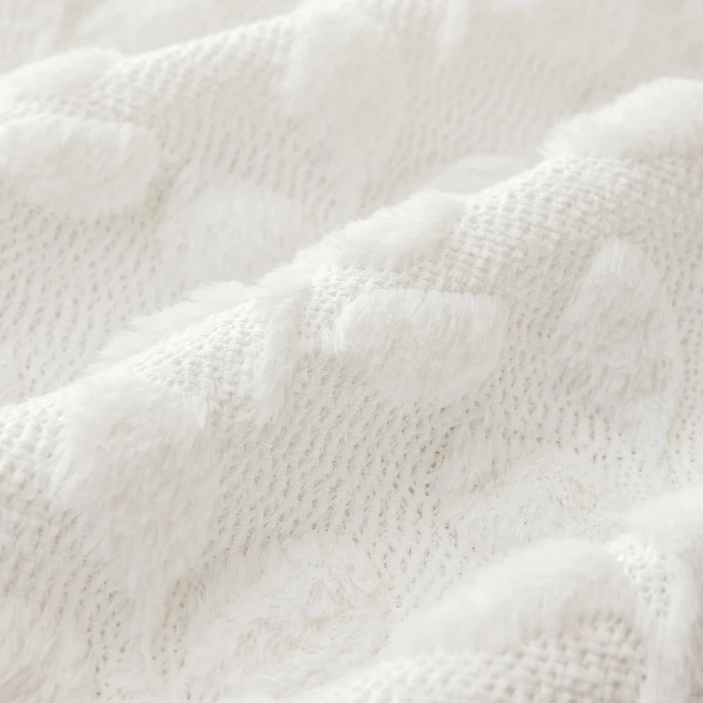 Close-up texture of white knitted faux fur pillow covers showing soft, fluffy fibers.