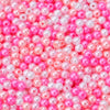 A close-up of small, round imitation pearl beads in shades of pink and magenta.