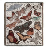 A throw blanket featuring a bohemian geometric pattern of various butterflies and floral elements on a neutral background.
