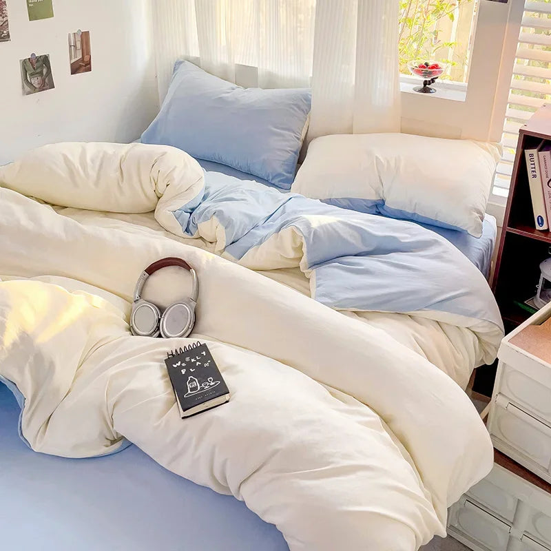 A bed with a light blue linen set featuring white and pale blue bedding and pillows.