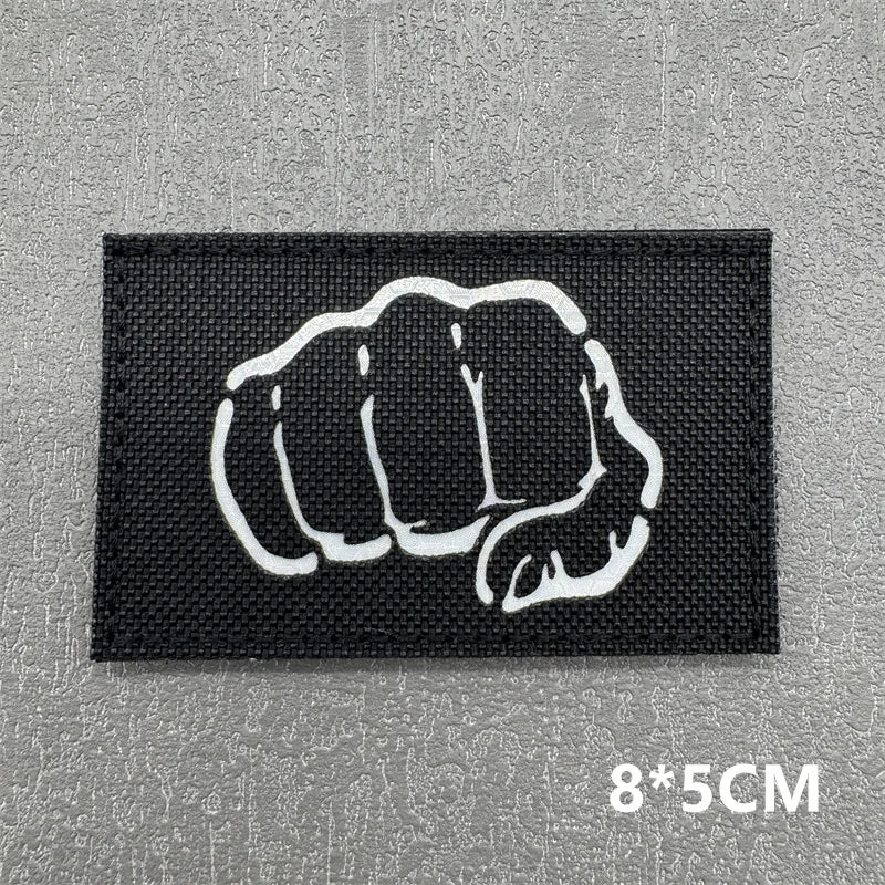 Black tactical patch featuring a white clenched fist design