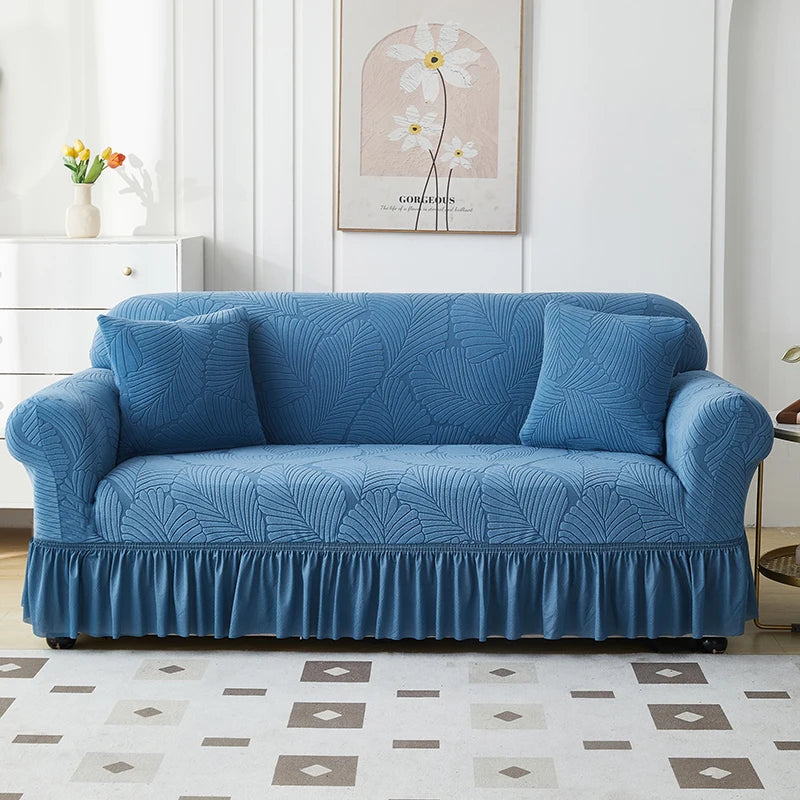 A deep blue jacquard elastic sofa cover featuring a pleated skirt and decorative texture.