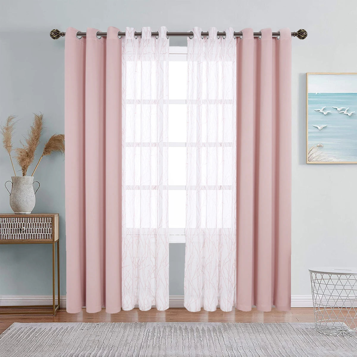 A set of pink sheer and blackout window drapes hanging on a rod in a light gray room.