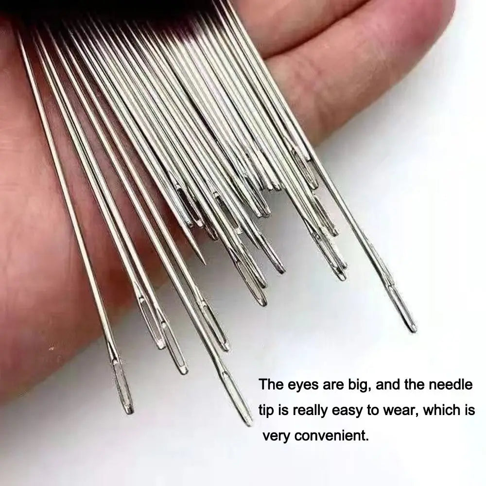 A hand holds a bundle of premium stainless steel sewing needles with large, easy-to-wear tips.