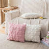 Two pink and white faux fur pillow covers resting on a beige sofa and a light rug.