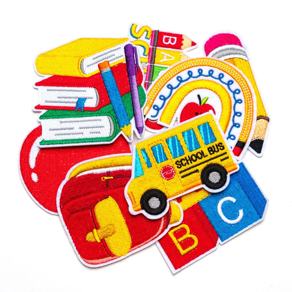 A collection of iron-on decorative patches featuring letters, a school bus, and other colorful designs.