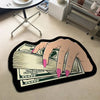 A hand is holding a fan of US dollar bills on a black decorative rug.