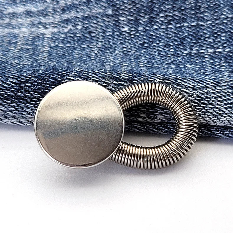 Silver spring-loaded button attached to a denim fabric background.