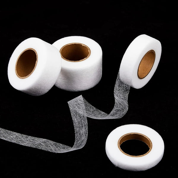 Rolls of white heavy duty iron-on hemming tape with loose strands unwinding