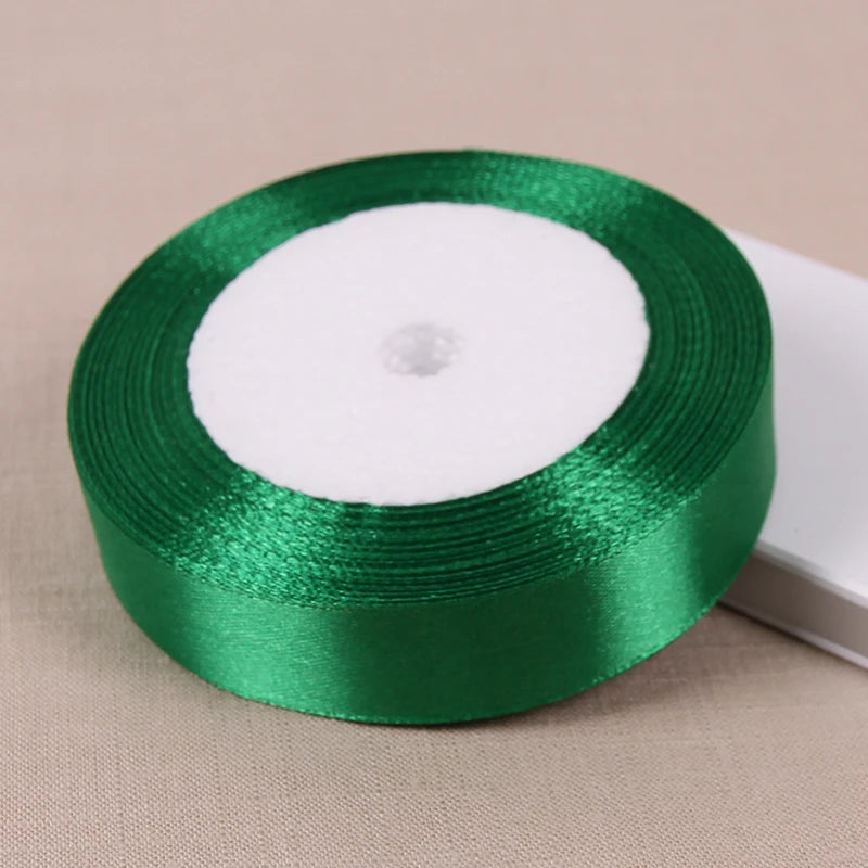 A roll of green satin ribbon used for crafting and decoration, shown on a light background.