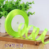 Roll of bright lime green satin ribbon used for crafting or decoration