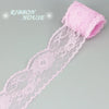 Pink decorative lace ribbon roll with a ruffled edge and delicate floral pattern.