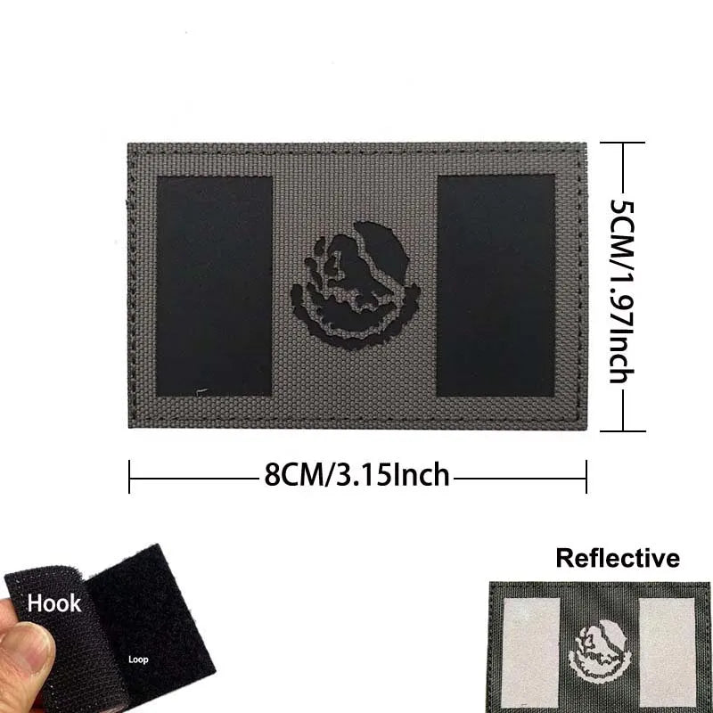 A rectangular black embroidery patch featuring a national flag design on a gray fabric background.