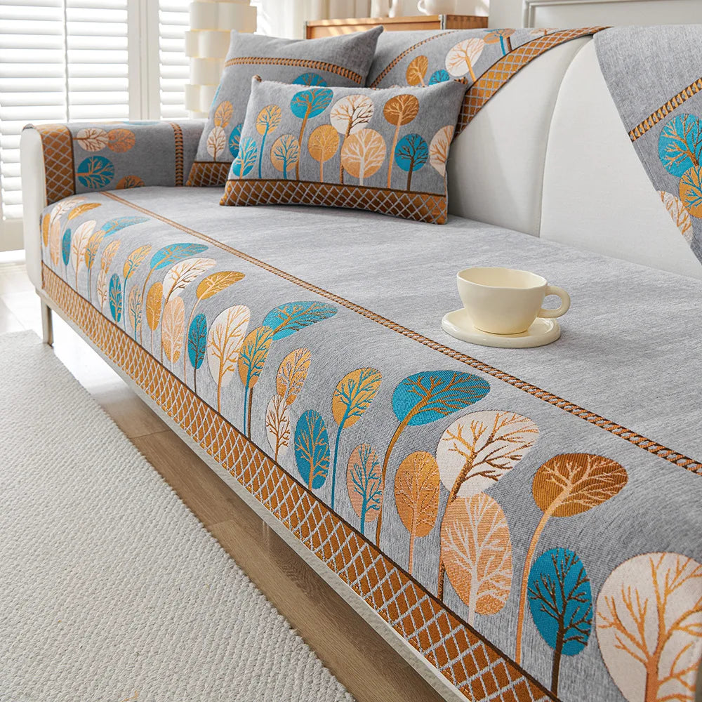 A gray jacquard sofa seat and back cover featuring a pattern of stylized leaves in blue, orange, and white tones.