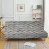 A gray velvet non-slip armless sofa cover displayed on a wooden floor with a patterned rug.
