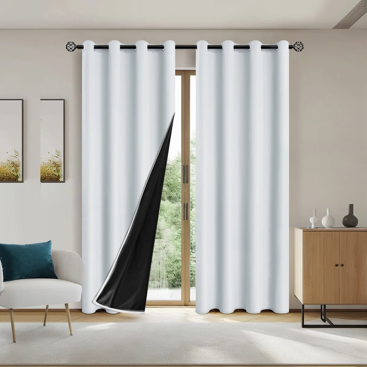 Solid black blackout curtains hanging in a window frame with light-colored furniture visible.