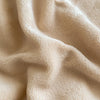 Close-up of soft beige luxury velvet bedding fabric draped and folded