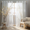 White sheer tulle window curtains hanging in a light-filled room with natural light streaming through.