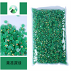 Bag of green resin rhinestones and a single green gemstone sample.